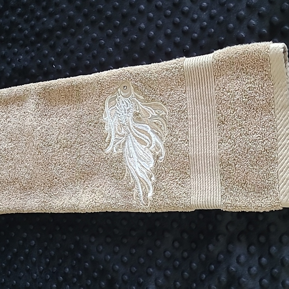 Hand towel tan with a  embroidered  fish